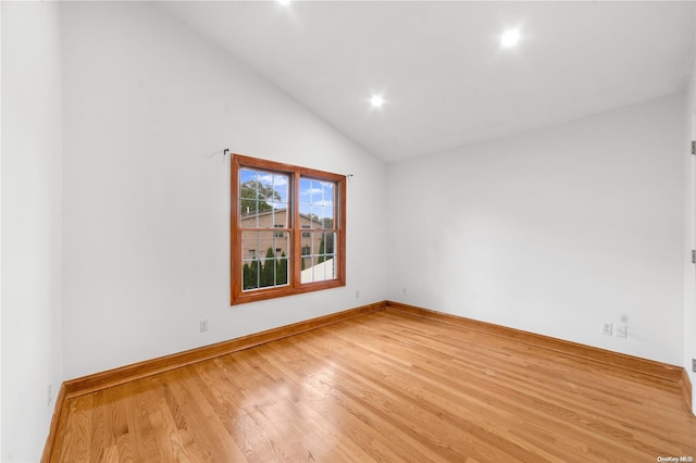 spare room featuring light hardwood / wood-style floors and vaulted ceiling