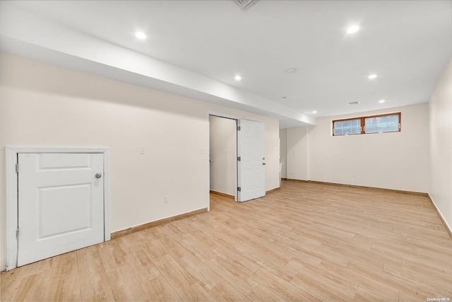 basement with light hardwood / wood-style floors