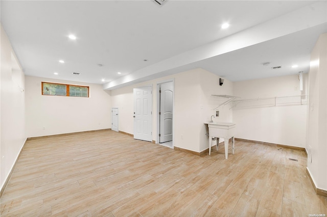 basement with light hardwood / wood-style floors