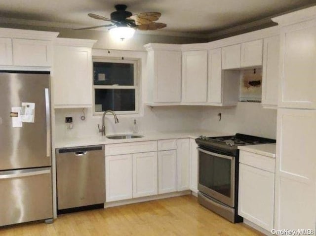 kitchen with white cabinetry, sink, ceiling fan, stainless steel appliances, and light hardwood / wood-style floors