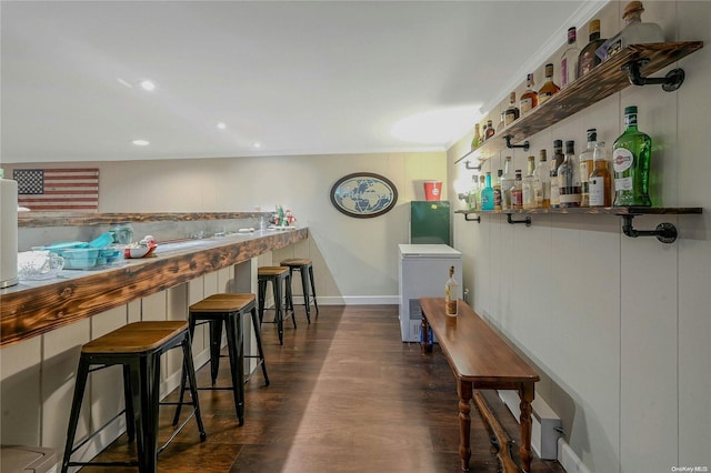 bar featuring wood walls, dark wood-type flooring, and fridge