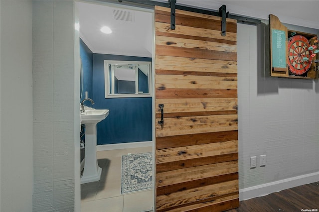 bathroom with ornamental molding, hardwood / wood-style flooring, and wooden walls