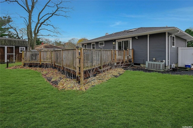 rear view of property with central AC, a lawn, and a wooden deck