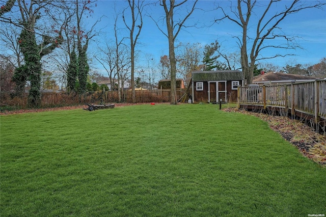 view of yard featuring a wooden deck and a storage unit