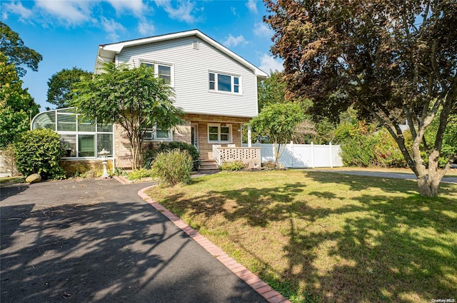 view of front of home with a lanai and a front yard