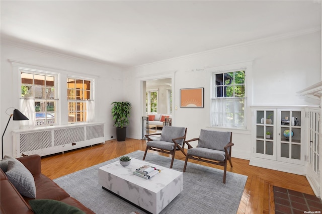 living room with hardwood / wood-style floors, a healthy amount of sunlight, crown molding, and radiator