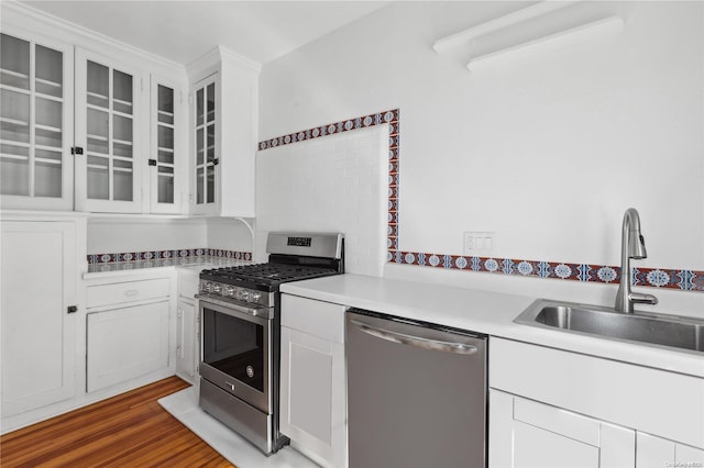 kitchen with dark hardwood / wood-style flooring, white cabinetry, sink, and appliances with stainless steel finishes