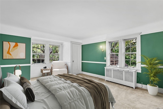 bedroom featuring light carpet and radiator