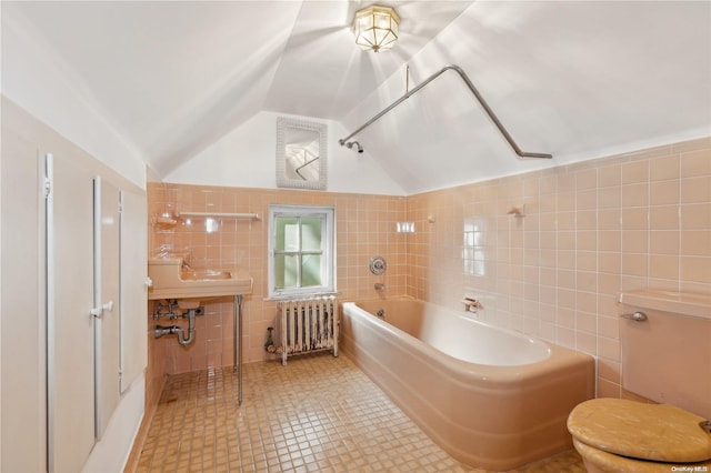 bathroom with radiator heating unit, tile patterned floors, lofted ceiling, toilet, and tile walls