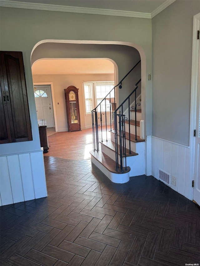 foyer featuring parquet flooring and ornamental molding