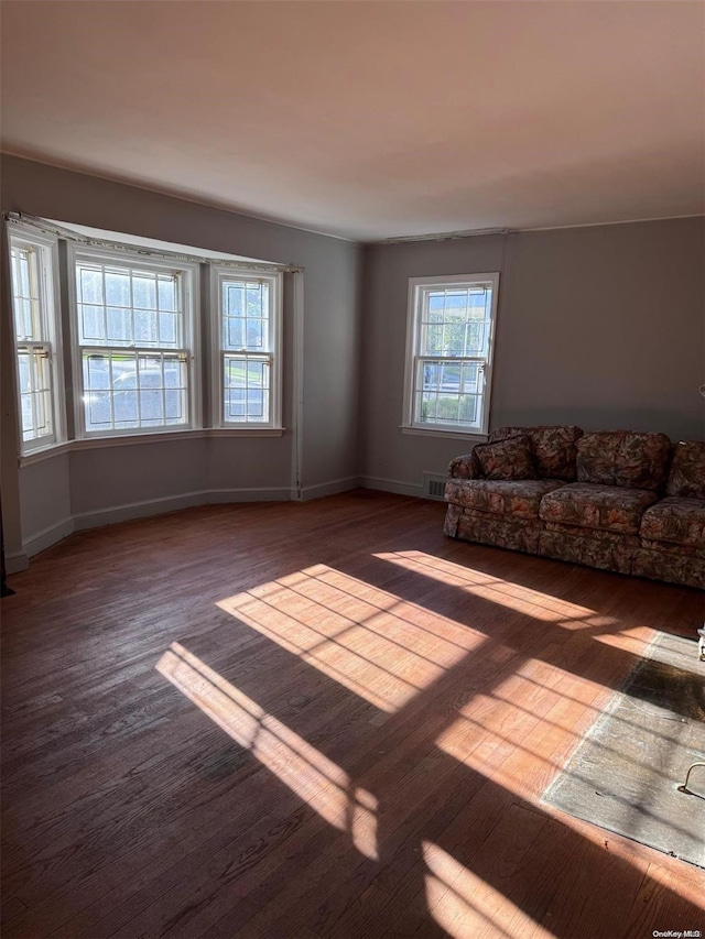 unfurnished living room with dark wood-type flooring