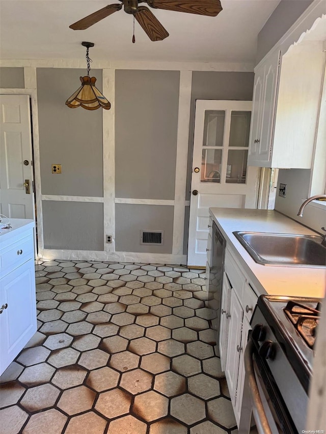 kitchen with pendant lighting, white cabinetry, sink, and stainless steel stove