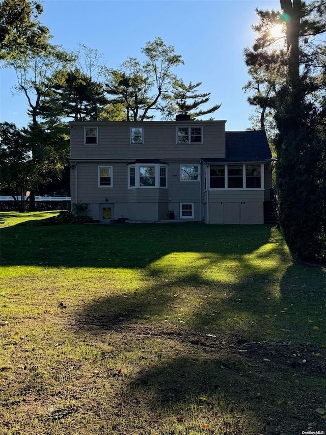 view of front of home with a sunroom and a front lawn