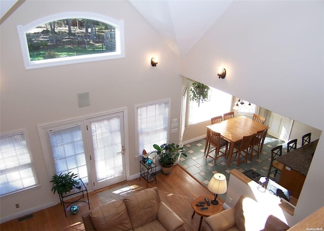 living room featuring high vaulted ceiling and wood-type flooring