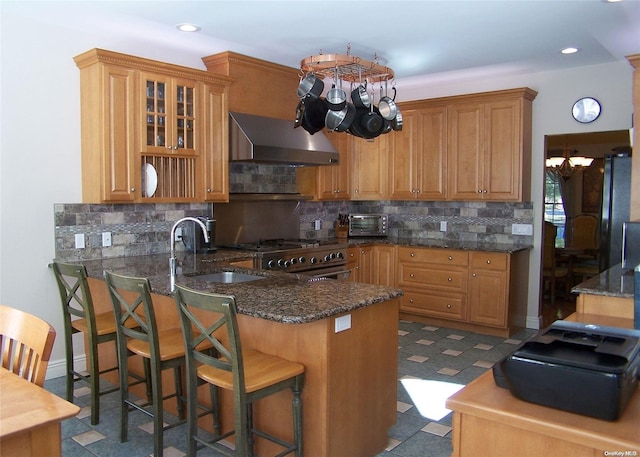 kitchen featuring kitchen peninsula, sink, stainless steel range, and a chandelier