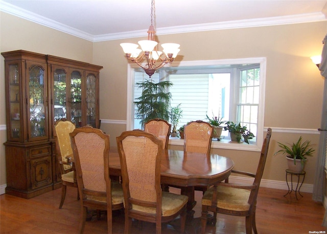 dining area featuring a chandelier, hardwood / wood-style flooring, and ornamental molding