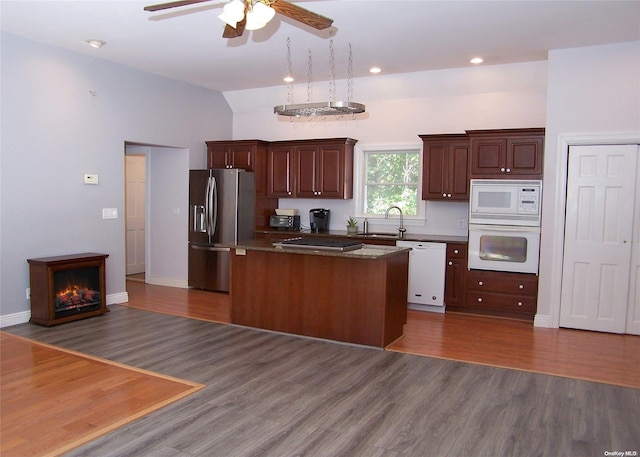 kitchen featuring a center island, white appliances, sink, dark hardwood / wood-style floors, and ceiling fan