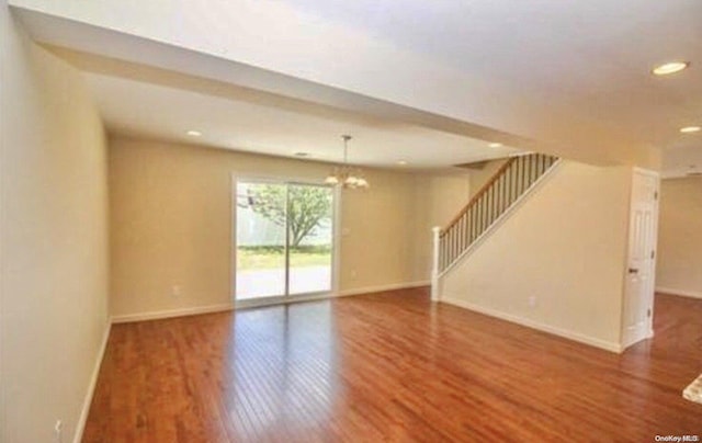 unfurnished room featuring wood-type flooring and a chandelier