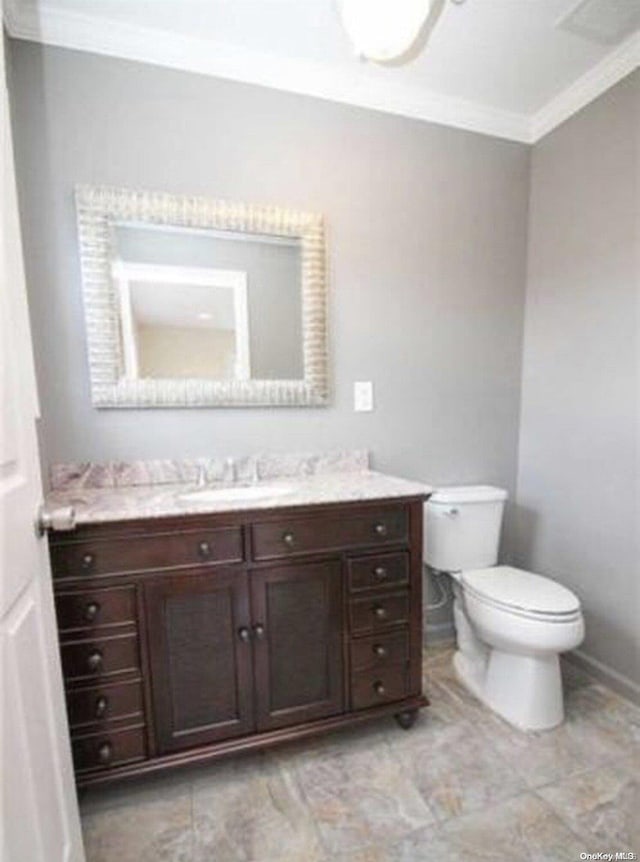 bathroom featuring toilet, vanity, and ornamental molding