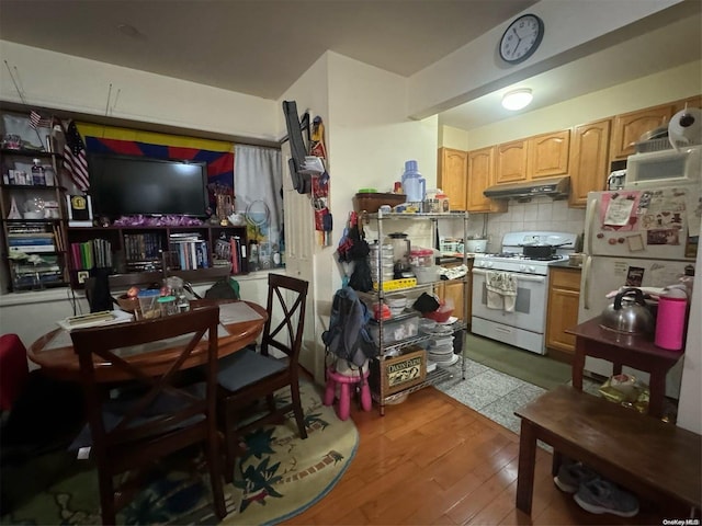 kitchen featuring tasteful backsplash, light hardwood / wood-style flooring, and white appliances