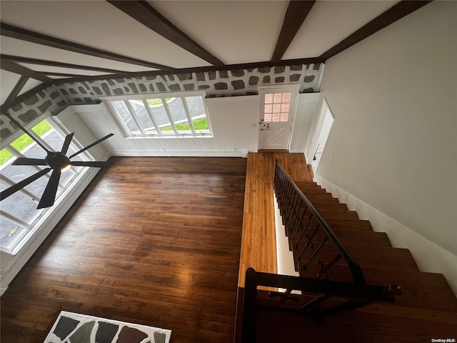 stairs with beam ceiling, ceiling fan, and wood-type flooring