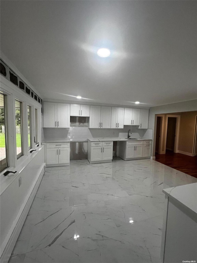 kitchen with white cabinetry, sink, and baseboard heating