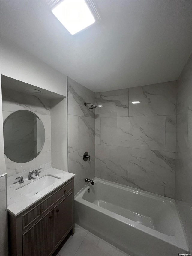 bathroom featuring tiled shower / bath combo and vanity