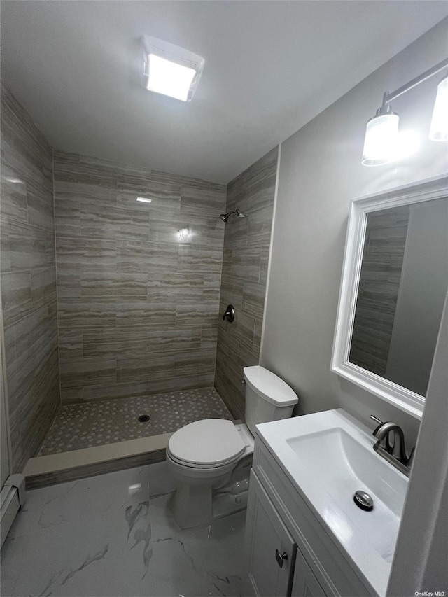 bathroom featuring tiled shower, vanity, and toilet