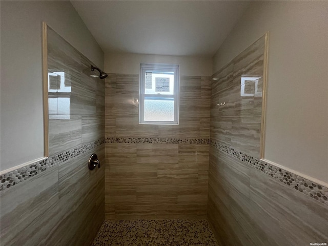 bathroom featuring tiled shower and tile walls