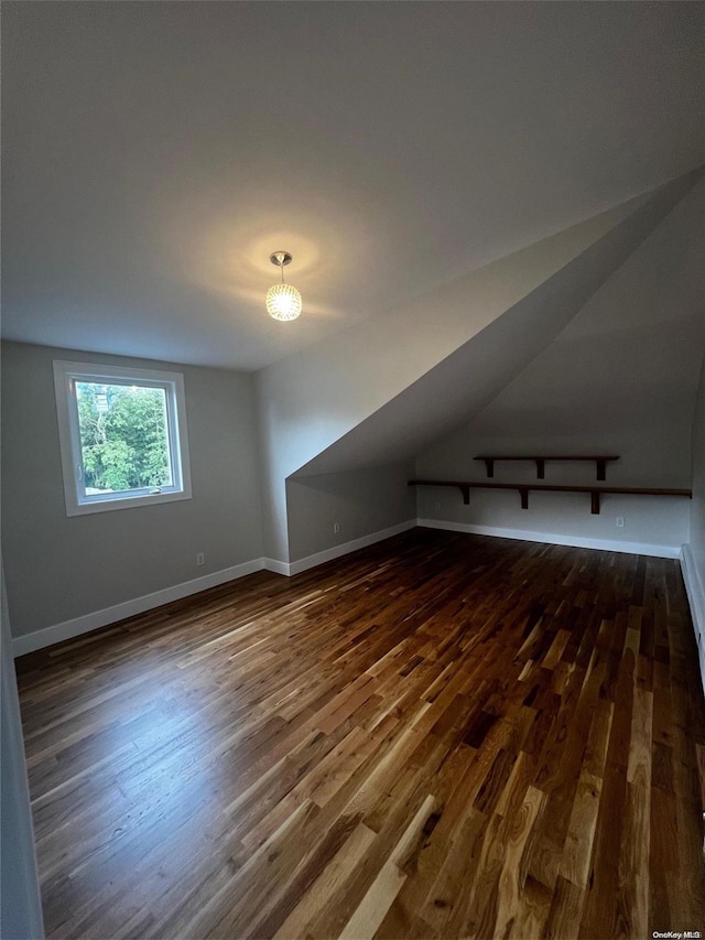 additional living space with lofted ceiling and dark wood-type flooring