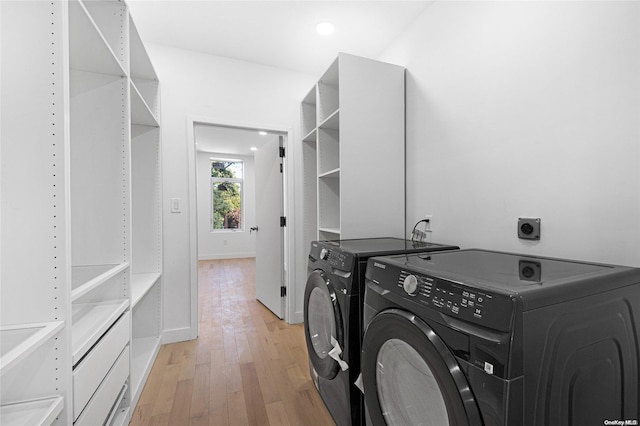 laundry room featuring washing machine and dryer and light hardwood / wood-style flooring