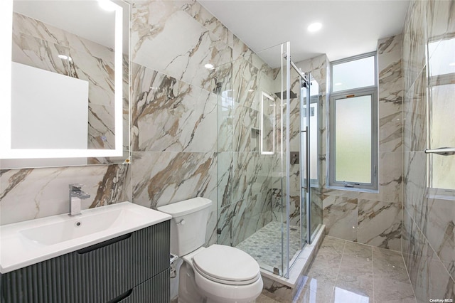 bathroom with vanity, a shower with door, toilet, and tile walls