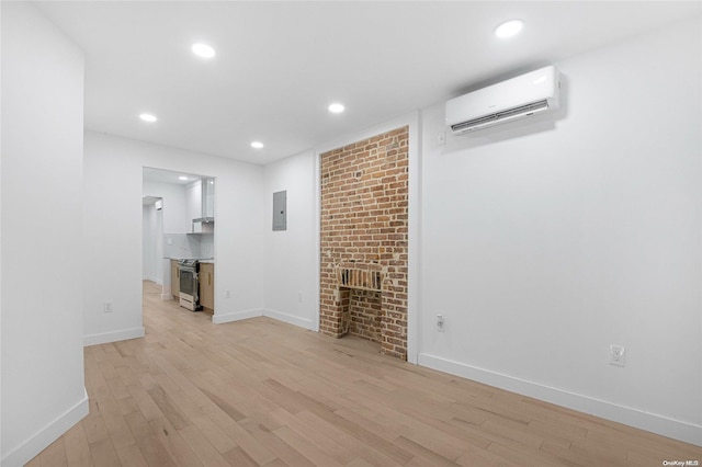 unfurnished living room featuring a brick fireplace, light wood-type flooring, electric panel, and an AC wall unit