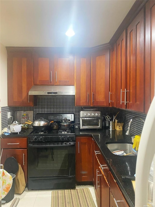 kitchen featuring sink, decorative backsplash, dark stone countertops, light tile patterned floors, and black gas range oven