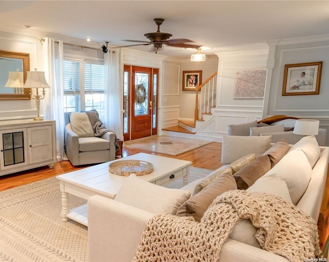 living room featuring light hardwood / wood-style flooring, ceiling fan, and crown molding