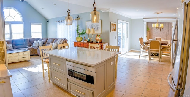 kitchen with a kitchen island, decorative light fixtures, a kitchen bar, light tile patterned floors, and appliances with stainless steel finishes