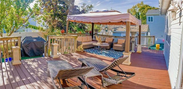 wooden terrace featuring a gazebo, an outdoor hangout area, and a grill