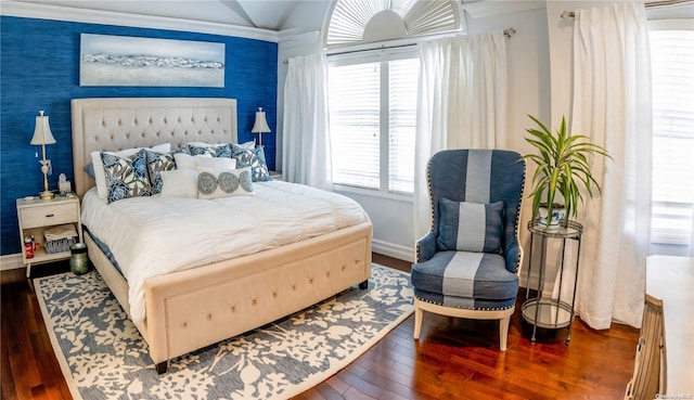 bedroom featuring wood-type flooring, lofted ceiling, and ornamental molding