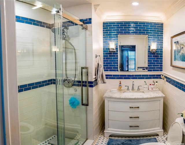 bathroom featuring vanity, tile patterned floors, ornamental molding, tile walls, and walk in shower