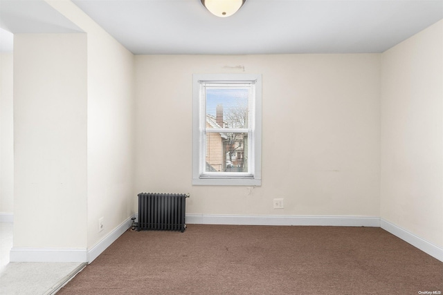 unfurnished room featuring radiator and carpet