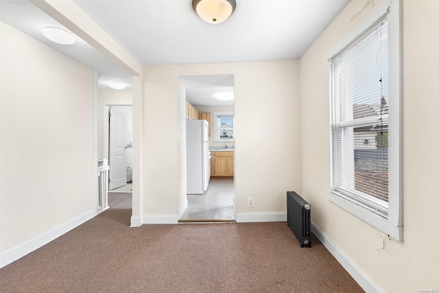 interior space with radiator heating unit and dark colored carpet