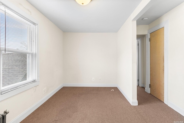 carpeted spare room featuring plenty of natural light