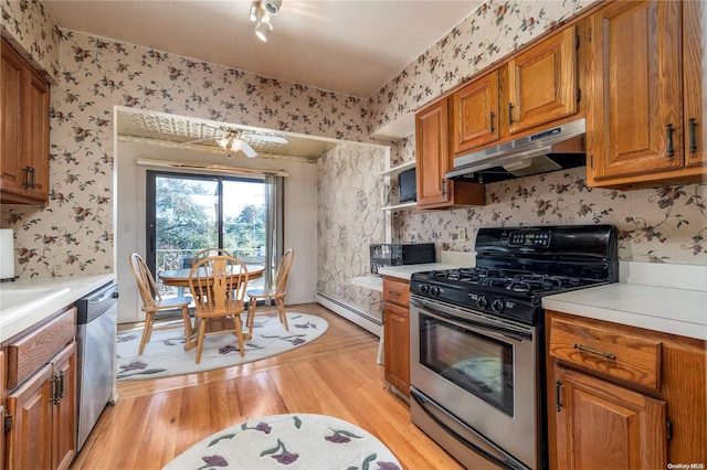 kitchen with stainless steel appliances, light hardwood / wood-style flooring, ceiling fan, and a baseboard heating unit