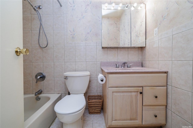 full bathroom with tiled shower / bath combo, tile patterned flooring, toilet, vanity, and tile walls