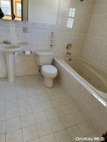 bathroom featuring sink, tile patterned flooring, tile walls, and toilet