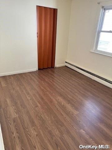 spare room featuring dark hardwood / wood-style flooring and baseboard heating