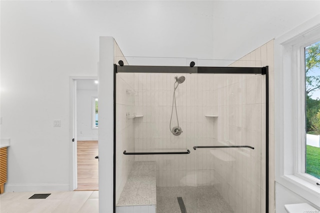 bathroom featuring wood-type flooring and a shower with shower door