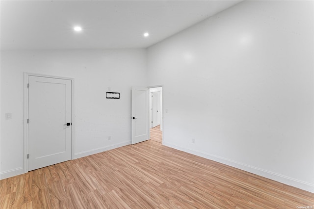 unfurnished room featuring light hardwood / wood-style floors and high vaulted ceiling