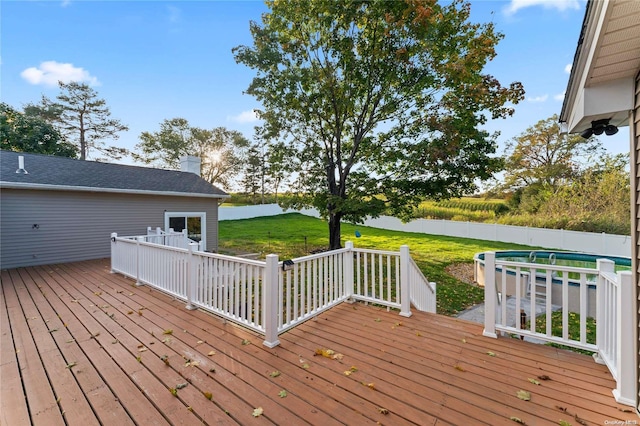 wooden terrace with a water view and a lawn