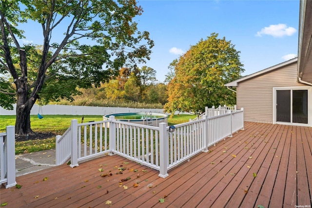 deck featuring a yard and a fenced in pool